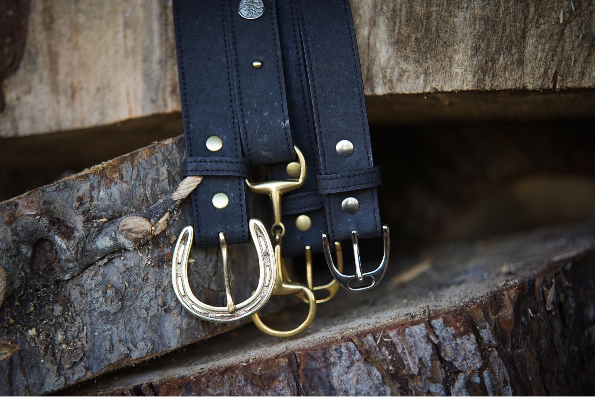 Equestrian themed belt range displayed hanging off a wooden stump
